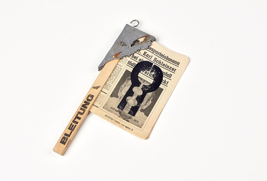 Heinz H. R. Decker, bleitung, 1975, Druck auf Zeitung, Holz, Blei, Plastik, 54 × 36 × 4 cm, Sch…