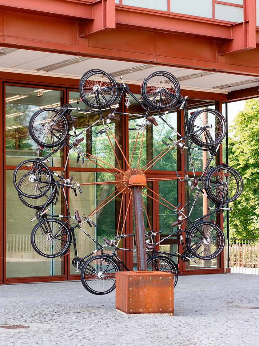 Peter Weibel, Das Rad des Realen, 1988/2014, 10 Fahrräder auf Trägerkonstruktion, Bleifigur, 44…